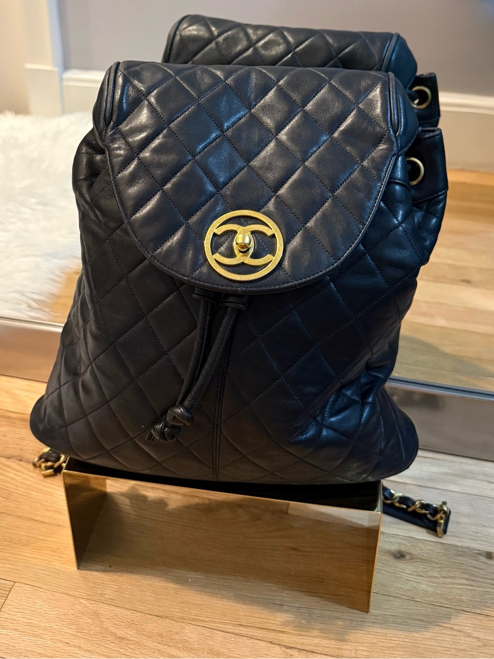 CHANEL Black Quilted Lambskin Drawstring Backpack with Gold CC Emblem